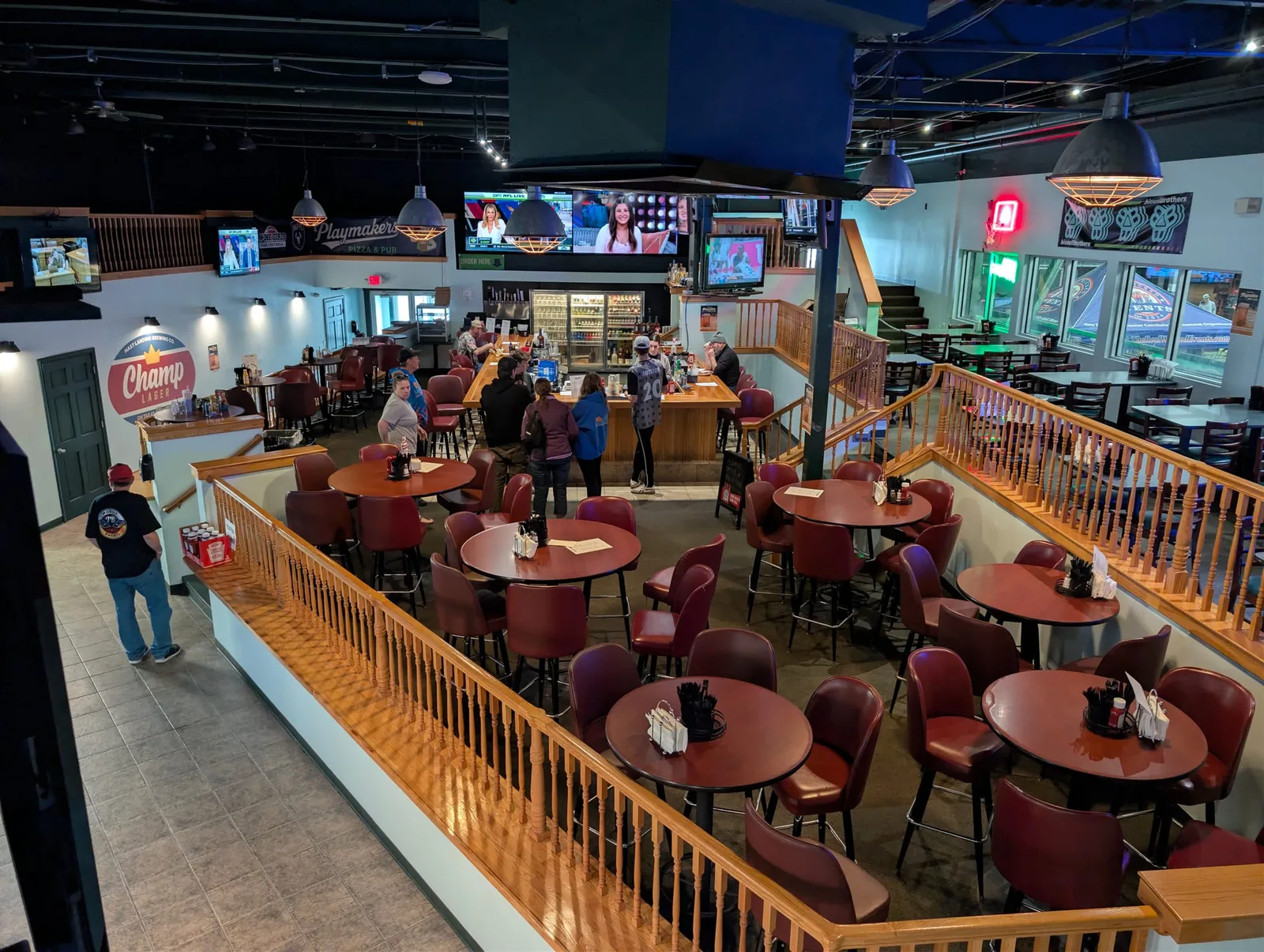 Wide view of Playmakers Pizza & Pub interior with TVs, bar, and dining floor